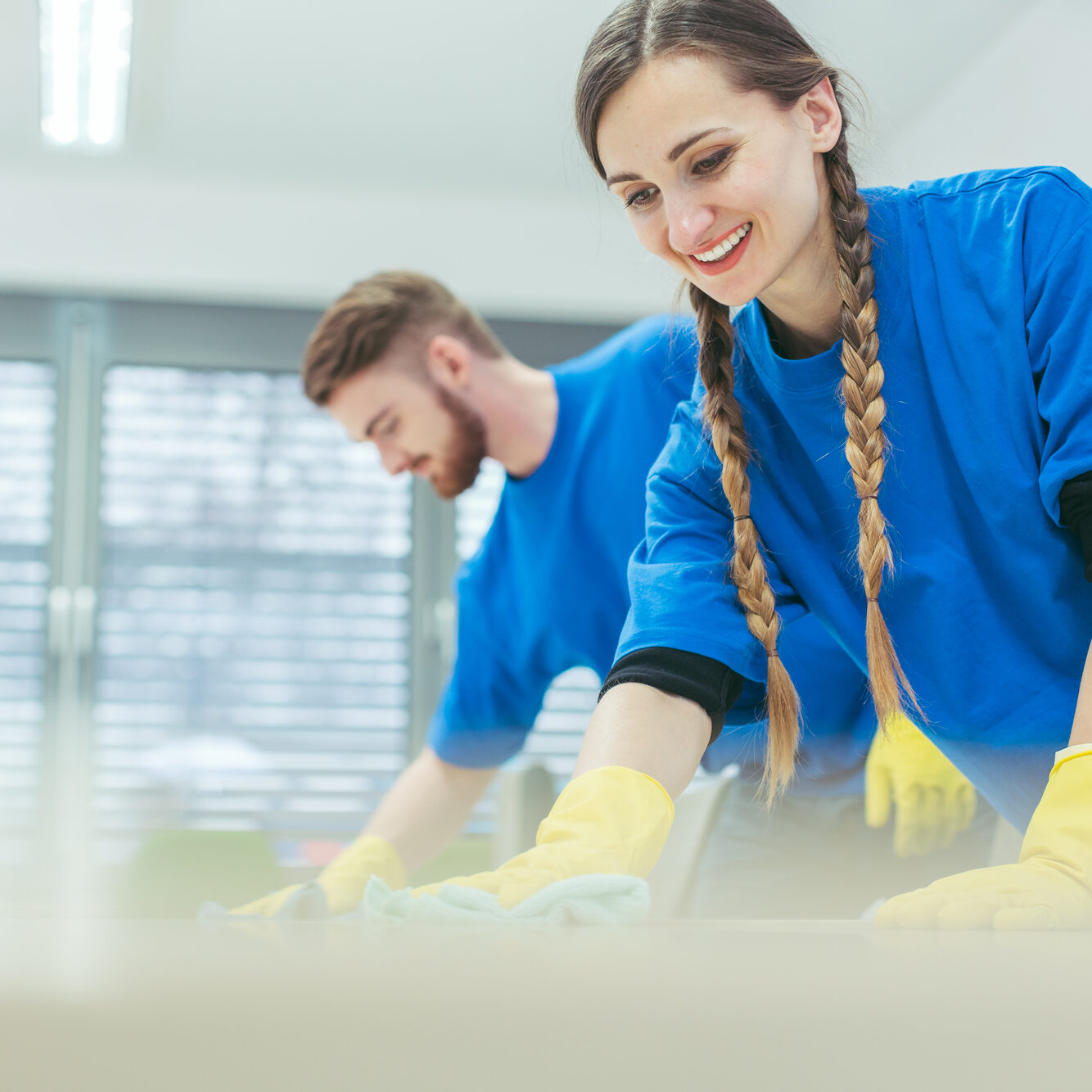 Cleaning crew wiping desks in an office building